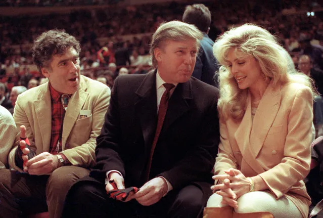 Actor Elliott Gould, left, joins Donald Trump and Marla Maples at courtside during the New York Knicks game against the Phoenix Suns at New York's Madison Square Garden, Tues., March 6, 1991. (Photo by Steve Freeman/AP Photo)