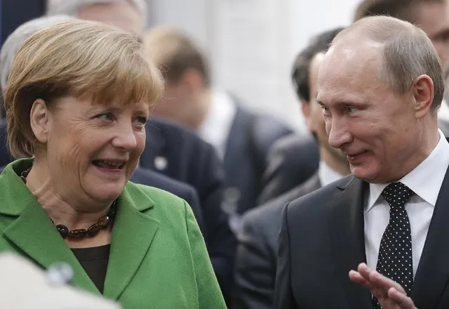 Russian President Vladimir Putin and German Chancellor Angela Merkel chat during the opening of the Hannover Fair in Hannover, Germany, Monday, April 8, 2013.(Photo by Frank Augstein/AP Photo)