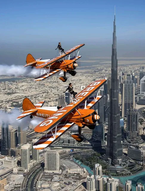 The British Breitling Wingwalkers, Danielle Hughes and Emily Guilding, fly past the Burj Khalifa, the world's tallest man-made structure, in Dubai at 2,000 feet (610 meters) in excess of 100mp/h, ahead of their Dubai debut performance at the 2014 UIM Skydive Dubai XCAT World Powerboating Series, on Saturday, 13th December 2014. (Photo by Katsuhiko Tokunaga/Breitling via AP Images)