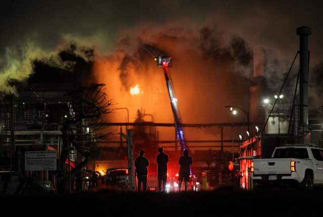 People stand near the Chevron refinery, where a large fire broke out, as firefighters work to contain the fire, in El Segundo, California, U.S., October 3, 2025. (Photo by Daniel Cole/Reuters)