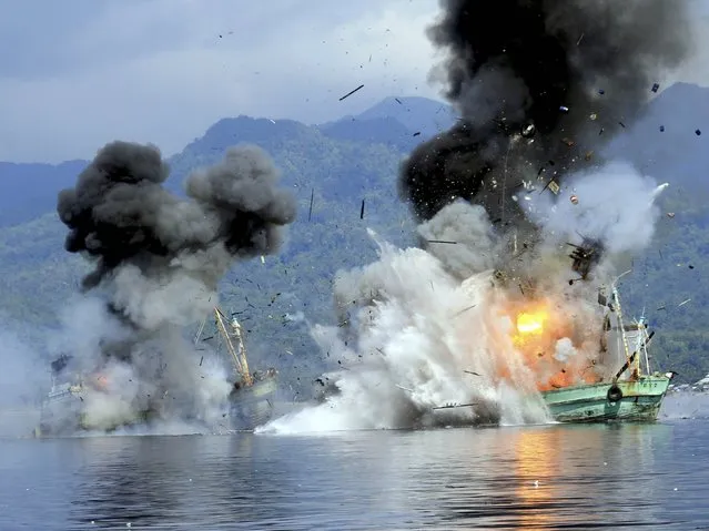 Two foreign flagged fishing boats registered in Papua New Guinea are destroyed by the Indonesian Navy after they were seized earlier for supposedly illegal fishing off the coast of Ambon, Maluku December 21, 2014 in this photo taken by Antara Foto. (Photo by Izaac Mulyawan/Reuters/Antara Foto)