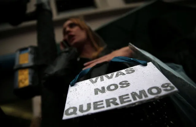 A woman talks on her cell phone as she carries a sign that reads “We want us alive” during a demonstration to demand policies to prevent gender-related violence, Argentina, October 19, 2016. (Photo by Marcos Brindicci/Reuters)