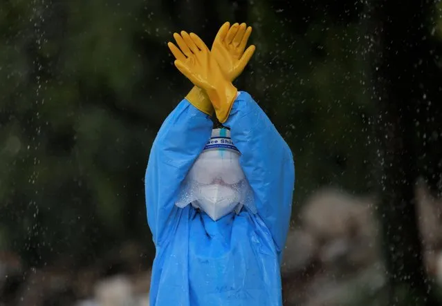 A female soldier wearing personal protective equipment (PPE) disinfects herself during a training on how to handle bodies of coronavirus victims, amidst the spread of the coronavirus disease (COVID-19), in Kathmandu, Nepal on October 15, 2020. (Photo by Navesh Chitrakar/Reuters)