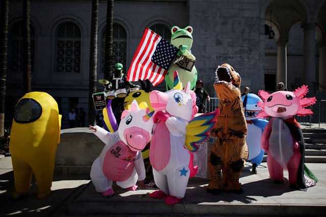 People wearing inflatable costumes, including unicorns, a dinosaur, and a frog holding a U.S. flag, gather during a ”No Kings” protest against U.S. President Donald Trump's policies, outside City Hall in Los Angeles, California, U.S., October 18, 2025. (Photo by Daniel Cole/Reuters)