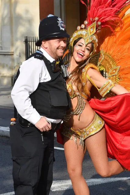 Brazilian dancer Juliana Campos poses with a police officer as she prepares to take part in the Notting Hill Carnival in west London on August 27, 2018. (Photo by John Stillwell/PA Images via Getty Images)