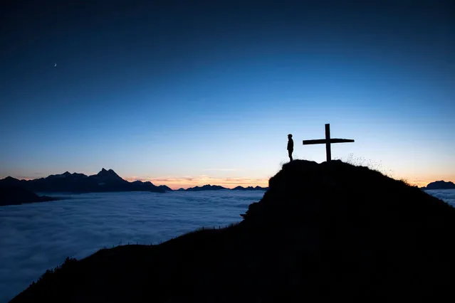 An image made available 06 October shows a person watching the sunset above the sea of fog on the summit of the Croix des Chaux/Chaux Ronde (2012m) above Gryon VD, western Switzerland, 05 October 2016. (Photo by Anthony Anex/EPA)