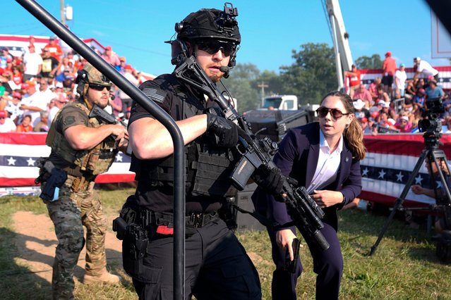 U.S. Secret Service agents respond as Republican presidential candidate former President Donald Trump is surrounded on stage by U.S. Secret Service agents at a campaign rally, Saturday, July 13, 2024, in Butler, Pa. (Photo by Evan Vucci/AP Photo)