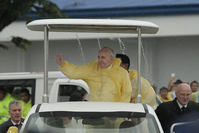 In this Saturday, January 17, 2015 file photo, Pope Francis waves to the faithful on his arrival in Tacloban, Philippines as rain drips from the roof of his vehicle. For months, Francis has been drafting an encyclical on the environment and global warming which he hopes to release by June or July 2015. (Photo by Wally Santana/AP Photo)