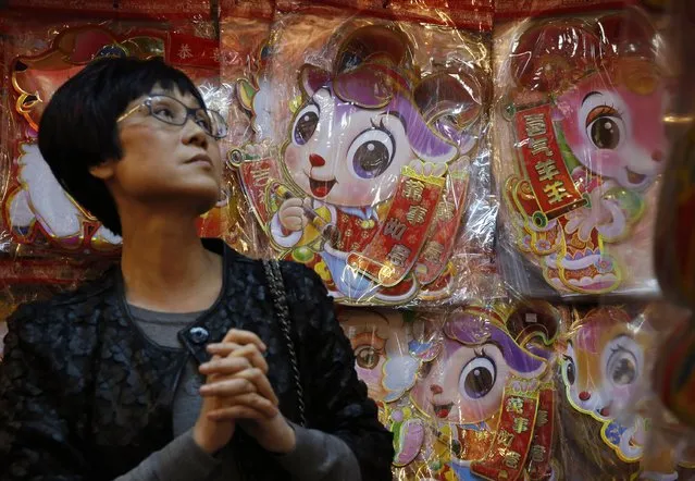 A woman chooses a goat's decoration to celebrate the upcoming Chinese Lunar New Year in Hong Kong, Wednesday, February 4, 2015. (Photo by Kin Cheung/AP Photo)