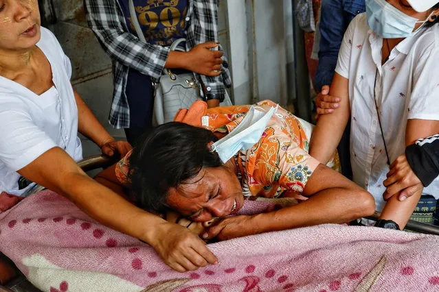 Family members cry over the dead body of a teenage boy Tun Tun Aung who was shot dead by security forces in front of his home on Monday, in Mandalay, Myanmar on March 23, 2021. (Photo by Reuters/Stringer)