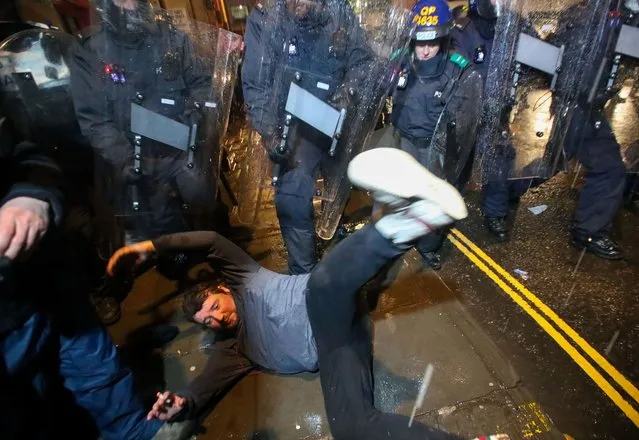 A demonstrator falls during a clash with police officers at a protest against a newly proposed policing bill, in Bristol, Britain, March 26, 2021. (Photo by Peter Cziborra/Reuters)