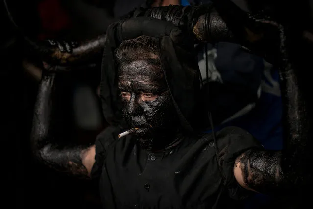 A man paints his face with oil and soot as he dresses up as a devil to join a carnival festival on February 14, 2015 in Luzon, Spain. (Photo by David Ramos/Getty Images)