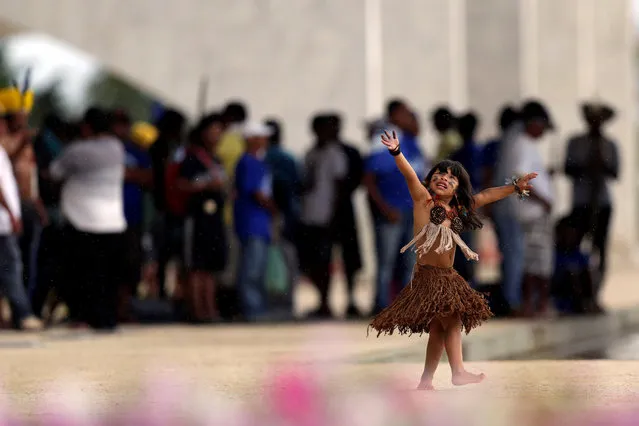 Indigenous children from the Kaingang ethnic group are seen dancing during a protest of indigenous people from various tribes that occupied the entrance of the Planalto Palace against agribusinesses and in demand of the demarcation of their ancestral lands, in Brasilia, Brazil November 22, 2016. (Photo by Ueslei Marcelino/Reuters)