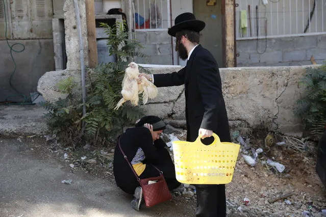 An ultra-Orthodox Jew performs a Jewish ritual called “Kaparot”, performed before Yom Kippur, the Day of Atonement and the holiest of Jewish holidays, in the Mea Shearim neighborhood in Jerusalem, Israel, 16 September 2018. The Kaparot is a blessing and prayer recited as a live fowl, or chicken is passed over a person's head, symbolically transferring that person's sins accumulated over the past year into the bird, which is butchered and eaten or donated to charity. Yom Kippur begins at sundown on 18 September, when the entire country comes to a standstill as people fast and spend much of the day in prayer. (Photo by Abir Sultan/EPA/EFE)