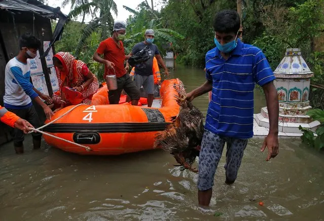 People are evacuated from a flooded area to safer places by the members of the National Disaster Response Force (NDRF) as Cyclone Yaas makes landfall at Ramnagar in Purba Medinipur district in the eastern state of West Bengal, India, May 26, 2021. (Photo by Rupak De Chowdhuri/Reuters)