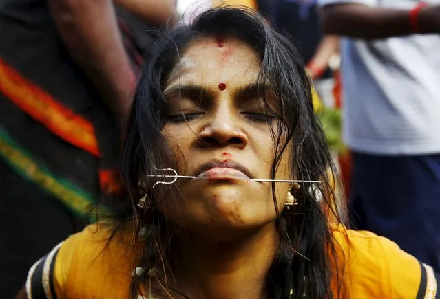 A Hindu devotee reacts after her tongue is pierced during Thaipusam at Batu Caves in Kuala Lumpur, Malaysia, January 23, 2016. (Photo by Olivia Harris/Reuters)