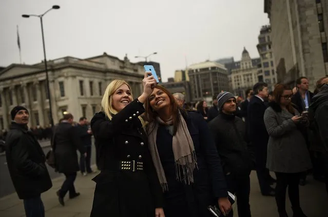 Commuters stop to stare and take photographs as they try to see a partial solar eclipse from London Bridge in London March 20, 2015. (Photo by Dylan Martinez/Reuters)