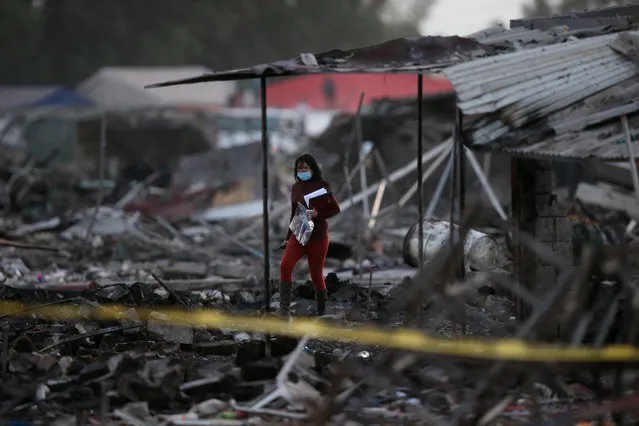 A woman walks amidst the remains of houses destroyed in an explosion at the San Pablito fireworks market outside the Mexican capital on Tuesday, in Tultepec, Mexico, December 20, 2016. (Photo by Edgard Garrido/Reuters)