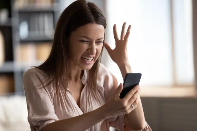 Mad young woman look at smartphone screen have operational gadget problems, angry millennial female feel stressed frustrated with slow Internet connection, bad service on modern cellphone device. (Photo by fizkes/Getty Images)
