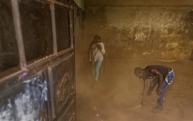In this photo taken Friday, December 9, 2016, young ballet dancers sweep the room of dust prior to practicing under the instruction of Kenyan ballet dancer Joel Kioko, 16, at a school in the Kibera slum of Nairobi, Kenya. (Photo by Ben Curtis/AP Photo)