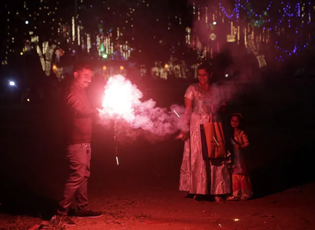 Indians light fire crackers as they celebrate Diwali, the festival of lights at a playground in Mumbai, India, Wednesday, November 7, 2018. (Photo by Rajanish Kakade/AP Photo)