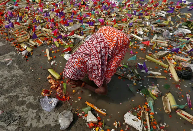 A woman worships after floating a small decorated boat made with banana stem in the waters of the Ganga river on the occasion of the annual Hindu festival of “Karthik Purnima” in Kolkata, India, November 23, 2018. (Photo by Rupak De Chowdhuri/Reuters)