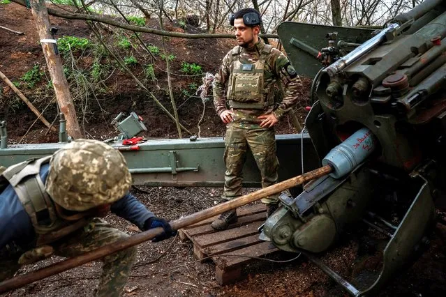 Servicemen of an artillery unit of the Armed Forces of Ukraine load a shell into a Giatsint-B howitzer before firing towards Russian troops at a position near a frontline, amid Russia's attack on Ukraine, at an undisclosed location in Donetsk region, Ukraine on November 4, 2023. (Photo by Alina Smutko/Reuters)