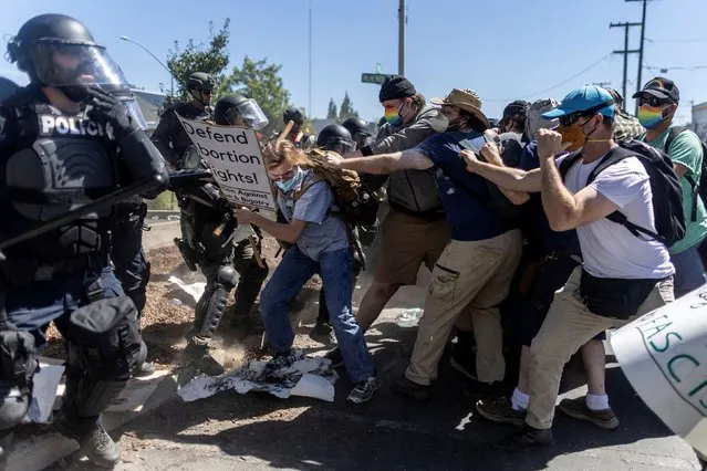 Counter-protesters clash with local police after a confrontation with Straight Pride Parade attendees at a rally outside a Planned Parenthood office in Modesto, California, U.S., August 27, 2022. (Photo by Carlos Barria/Reuters)