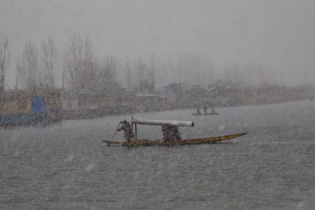 A Kashmiri man rows his shikara, a traditional wooden boat native to the region, in Srinagar, Indian controlled Kashmir, Thursday, February 11, 2016. Following continued snowfall, the Jammu-Srinagar highway, that connects Kashmir valley to the rest of India, was closed to traffic, news reports said. (Photo by Dar Yasin/AP Photo)