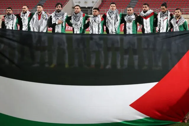Palestine's starting eleven gather for their national anthem ahead of the 2026 FIFA World Cup AFC qualifiers football match between Lebanon and Palestine at the Khalid Bin Mohammed Stadium in Sharjah on November 16, 2023. (Photo by Giuseppe Cacace/AFP Photo)
