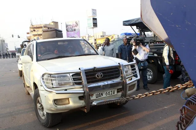 Police uses a chain to tow the car of Uganda's leading opposition party Forum for Democratic Change presidential candidate Kizza Besigye with him inside as police and military officers disperses his procession with his supporters to a campaign ground, in Kampala, Uganda, February 15, 2016. (Photo by James Akena/Reuters)