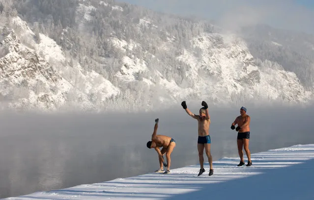 Members of the Dolphin winter swimming club warm up on an embankment of the Yenisei River ahead of their weekly bathing session, with the air temperature at about minus 28 degrees Celsius (18.4 degrees Fahrenheit), in the Siberian town of Divnogorsk, Russia February 8, 2019. (Photo by Ilya Naymushin/Reuters)