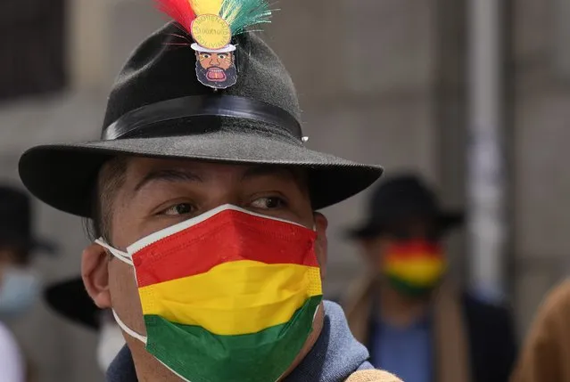 A performer wears a mask with a Bolivian flag motif, due to the COVID-19 pandemic, as he dances on the National Day of the Morenada Dance in La Paz, Bolivia, Tuesday, September 7, 2021. La Morenada is a folk dance from the Andes that was inspired by slaves brought to the region during the colonial era. (Photo by Juan Karita/AP Photo)