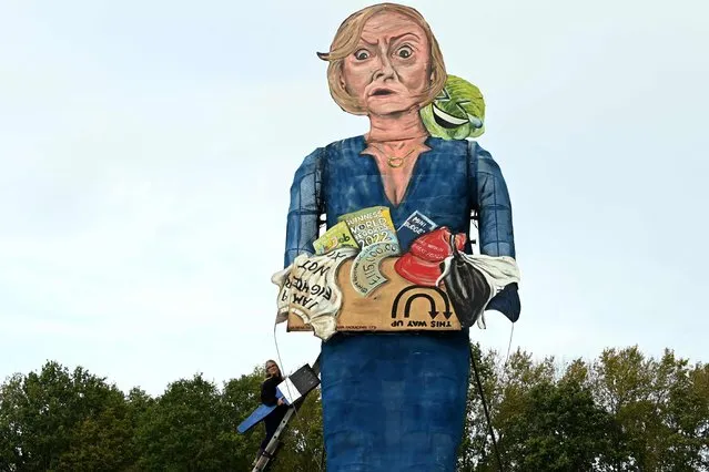 Artist Andrea Deans poses with the Edenbridge Bonfire Society's 2022 “Celebrity Guy”, former British prime minister Lizz Truss, during the unveiling in Edenbridge, southern England on November 2, 2022. The giant effigy of Liz Truss, will be burned at the Edenbridge Bonfire Society's annual bonfire night celebrations on November 5, 2022. (Photo by Glyn Kirk/AFP Photo)