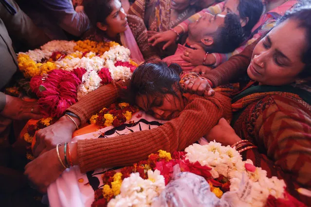 Sanjana cries over the body of her husband Mahesh Yadav, a Central Reserve Police Force (CRPF) soldier who was killed in Thursday bombing in Kashmir, in Tudihar village, some 56 kilometers east of Prayagraj, Uttar Pradesh state, India, Saturday, February 16, 2019. As India considers its response to the suicide car bombing of a paramilitary convoy in Kashmir that killed dozens of soldiers, a retired military commander who oversaw a much-lauded military strike against neighboring Pakistan in 2016 has urged caution. (Photo by Rajesh Kumar Singh/AP Photo)