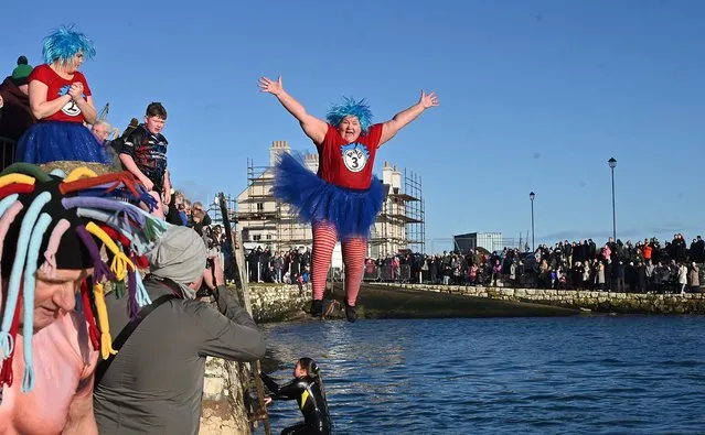 Revellers brave the chill and jump into the water at Carnlough, Co. Antrim, Northern Ireland on January 1, 2024. (Photo by Arthur Allison/Pacemaker)