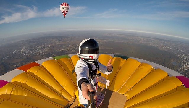This selfie picture taken on November 10, 2021, shows French balloonist Remi Ouvrard attempting to set a world record by standing on the top of a hot air balloon for the Telethon at an altitude of over 3637 meters, in Chatellerault, western France. (Photo by Remi Ouvrard/AFP Photo)