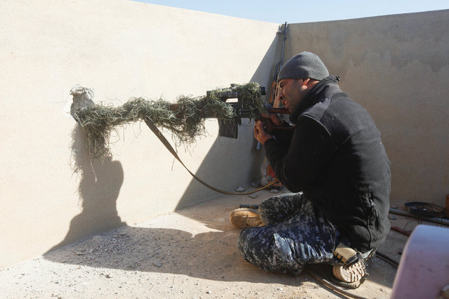 A sniper from Iraq's Federal Police force takes aim at Islamic State positions from the roof of a house on the frontline in Albu Saif, south of Mosul, Iraq February 21, 2017. (Photo by Alaa Al-Marjani/Reuters)