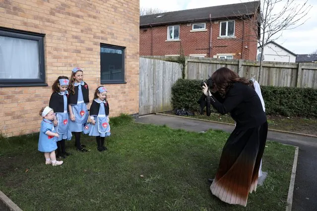 A woman takes a photograph of Jewish children dressed in costumes as they celebrate the annual holiday of Purim in Manchester, Britain on March 24, 2024. (Photo by Temilade Adelaja/Reuters)