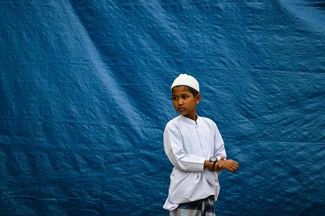 A Rohingya refugee child looks on before taking part in Eid al-Fitr prayers, marking the end of the holy month of Ramadan, at a temporary shelter in Meulaboh, Indonesia's Aceh province on April 10, 2024. (Photo by Chaideer Mahyuddin/AFP Photo)
