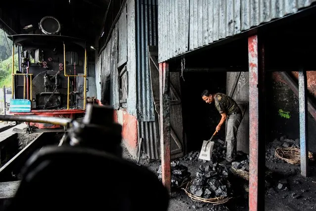 A worker breaks coal for a steam engine belonging to Darjeeling Himalayan Railway, which run on a 2 foot gauge railway and is a UNESCO World Heritage Site, at a station in Darjeeling, India, June 25, 2019. (Photo by Ranita Roy/Reuters)