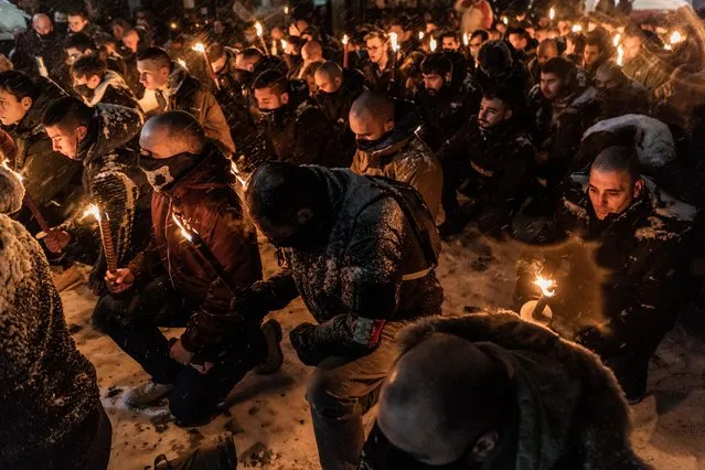 Ultra-Nationalists carry torches and knee on their knees in memory of General Hristo Lukov near the house he once lived as snow falls on February 13, 2021 in Sofia, Bulgaria. The Lukov March is an event held annually in Sofia since 2003, with the exception of 2020 when it was successfully banned, in honour of a pro-Nazi general and draws neo-Nazis from across Europe. The Lukov March is the subject of an online petition entitled “u201cStop fascist manifestations in the Bulgarian public space”u201d. (Photo by Hristo Rusev/Getty Images)