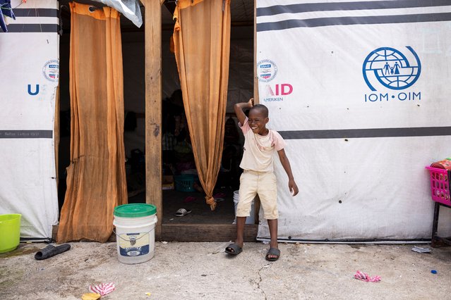 A boy displaced by gang war violence stands in front of a tent at the Antenor Firmin high school transformed into a shelter, where people live in poor conditions in Port-au-Prince, Haiti on May 1, 2024. (Photo by Ricardo Arduengo/Reuters)