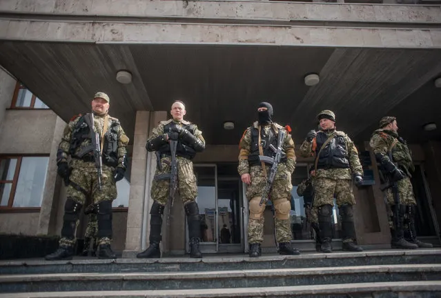 Armed men stands in front of the occupied police station in Slaviansk, Ukraine, April 14, 2014. (Photo by Roman Pilipey/EPA)