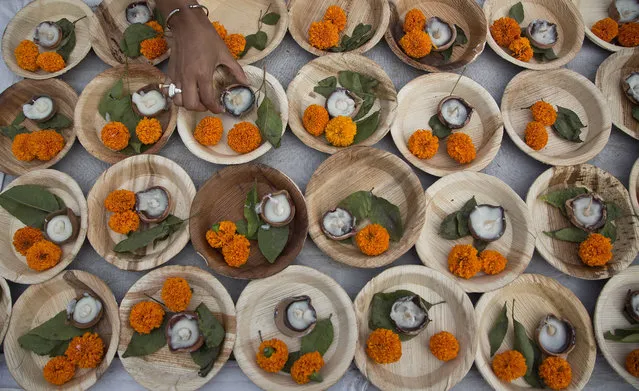 An Indian girl arranges earthen lamps to perform rituals during the inaugural ceremony of a five-day long Namami Brahmaputra festival in Gauhati, India, Friday, March 31, 2017. This is the first year of the festival. (Photo by Anupam Nath)a/AP Photo)