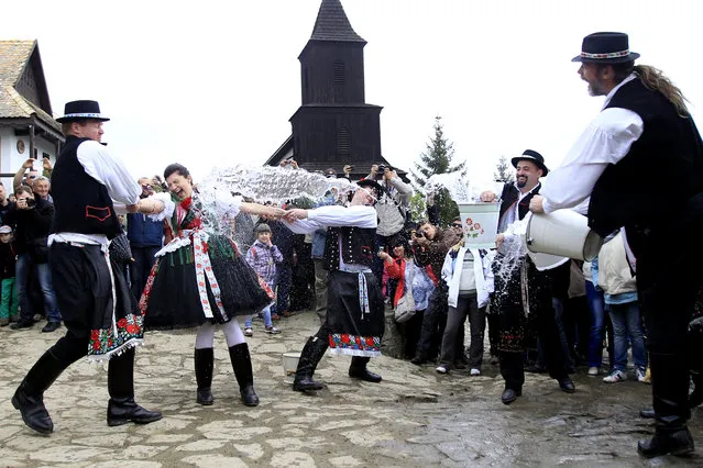 A man throws water on a woman as part of traditional Easter celebrations in Holloko, east of Budapest, April 21, 2014. Locals from the World Heritage village of Holloko celebrate Easter with the tradition “watering of the girls”, a Hungarian tribal fertility ritual rooted in the area's pre-Christian past. (Photo by Bernadett Szabo/Reuters)