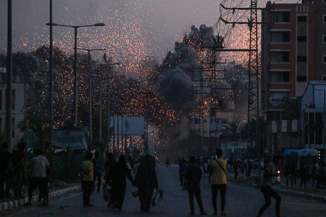 Palestinians watch smoke billowing following an Israeli airstrike in Deir al-Balah in the central Gaza Strip on June 6, 2024, amid the ongoing conflict between Israel and the Palestinian militant group Hamas. (Photo by Bashar Taleb/AFP Photo)