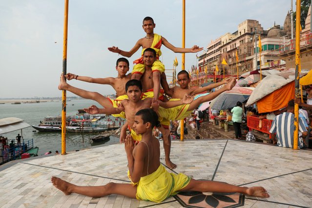 Sanskrit school students perform yoga asanas at Dashashwamedh Ghat to mark the International Day of Yoga, in Varanasi on June 21, 2024. (Photo by Niharika Kulkarni/AFP Photo)