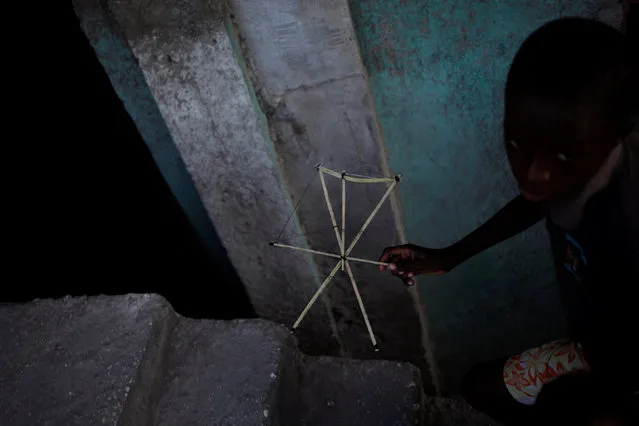 A boy walks carrying the frame of a kite in a neighborhood of Port-au-Prince, Haiti, February 8, 2017. (Photo by Andres Martinez Casares/Reuters)