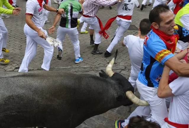 A runner is gored by a Jose Escolar fighting bull at Telefonica corner during the fifth running of the bulls of the San Fermin festival in Pamplona, northern Spain, July 11, 2015. (Photo by Vincent West/Reuters)